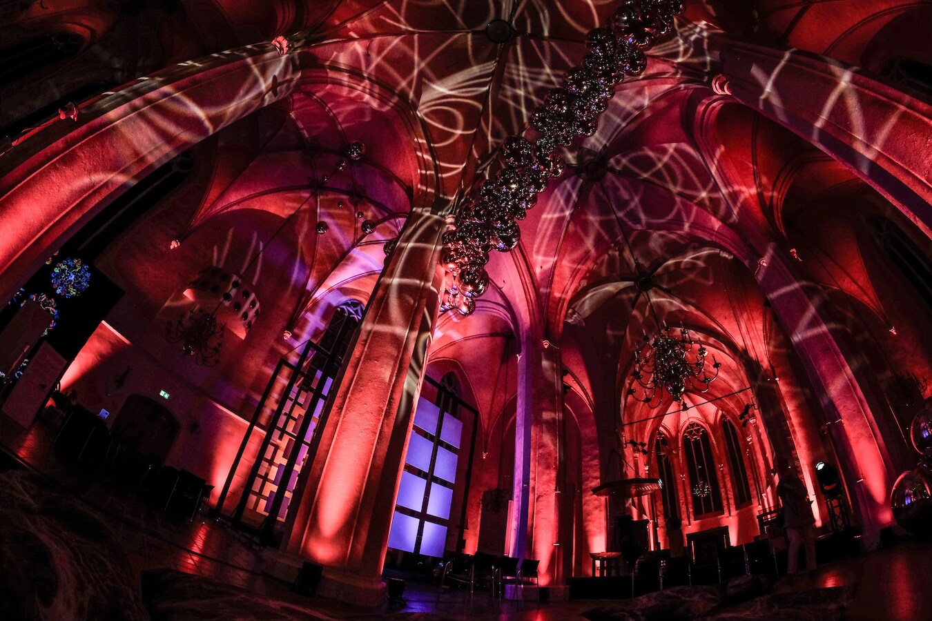 Sfeerimpressie van de Catharinakerk in Doetinchem tijdens een avondevenement met kleurrijke lichtprojecties.